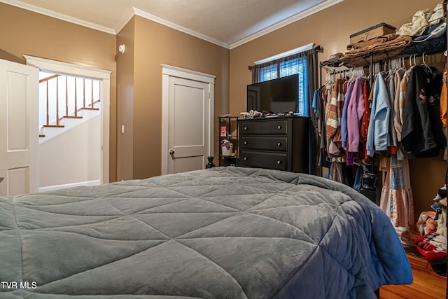 bedroom with hardwood / wood-style flooring and ornamental molding