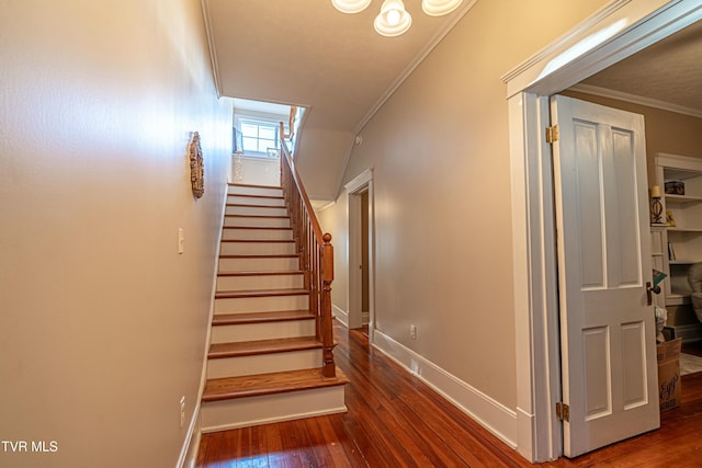 stairway with crown molding and wood-type flooring