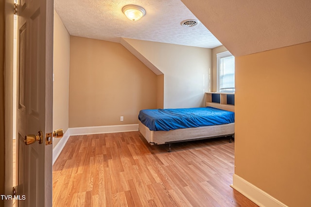 unfurnished bedroom featuring light hardwood / wood-style floors and a textured ceiling