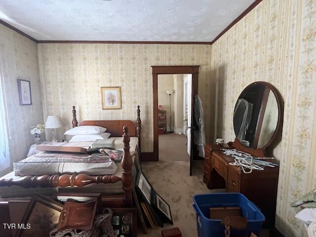 bedroom with a textured ceiling, carpet floors, and ornamental molding