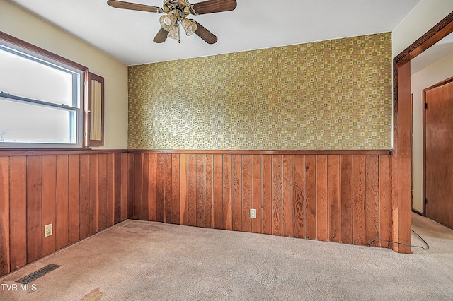 carpeted spare room featuring ceiling fan