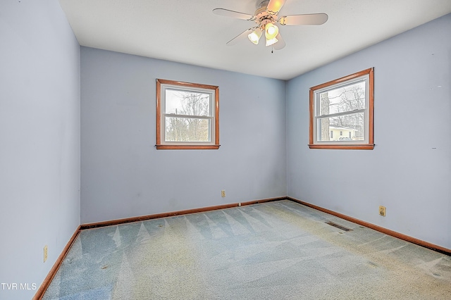 carpeted spare room with ceiling fan