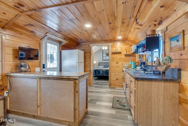 kitchen with lofted ceiling, light hardwood / wood-style flooring, light brown cabinetry, white refrigerator, and wooden ceiling