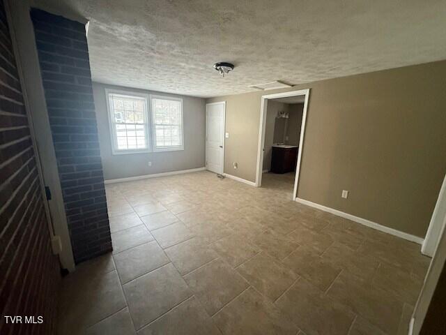 unfurnished room with a textured ceiling