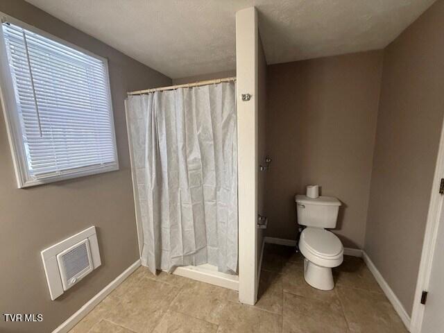 bathroom featuring toilet and a shower with curtain