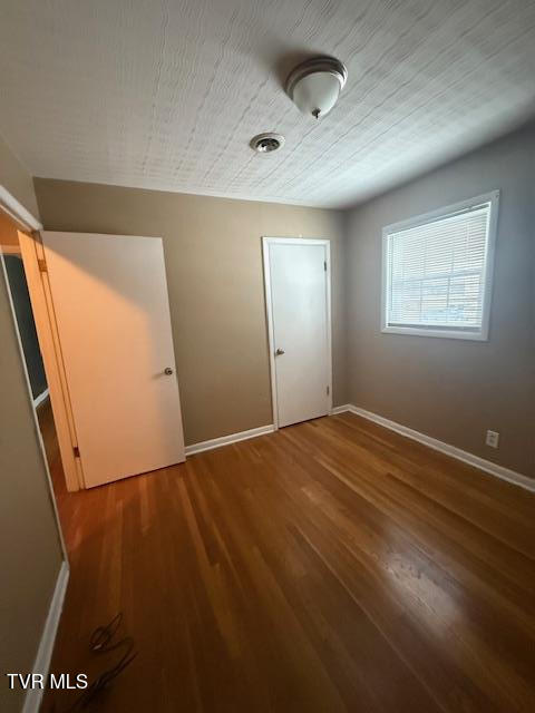 unfurnished bedroom with a textured ceiling and hardwood / wood-style floors