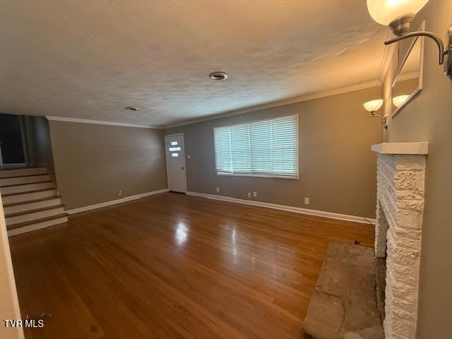 unfurnished living room featuring crown molding and wood-type flooring