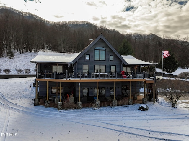 snow covered rear of property with a mountain view