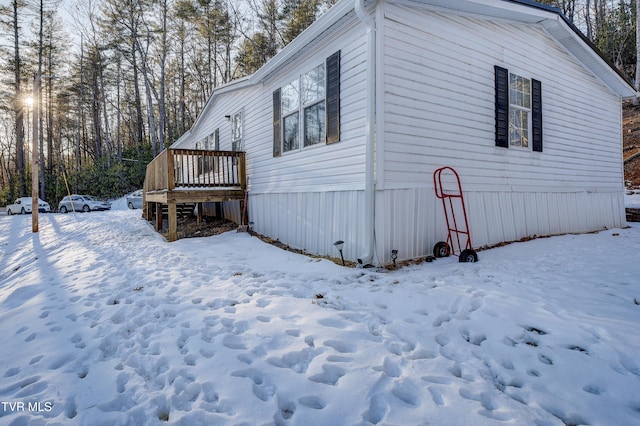 snow covered property featuring a wooden deck