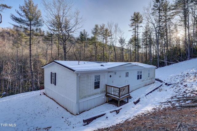 view of snow covered rear of property