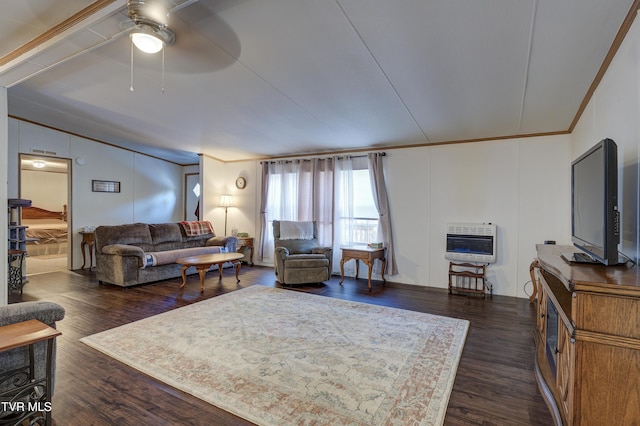 living room with heating unit, ceiling fan, dark wood-type flooring, and crown molding