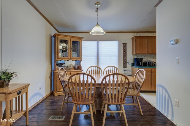 dining room featuring dark hardwood / wood-style floors and ornamental molding