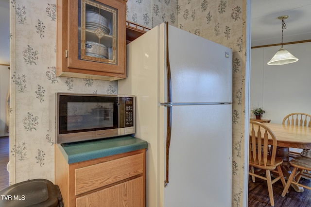 kitchen featuring decorative light fixtures, dark hardwood / wood-style floors, and white fridge