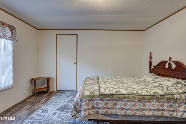 bedroom with a closet, crown molding, and hardwood / wood-style floors