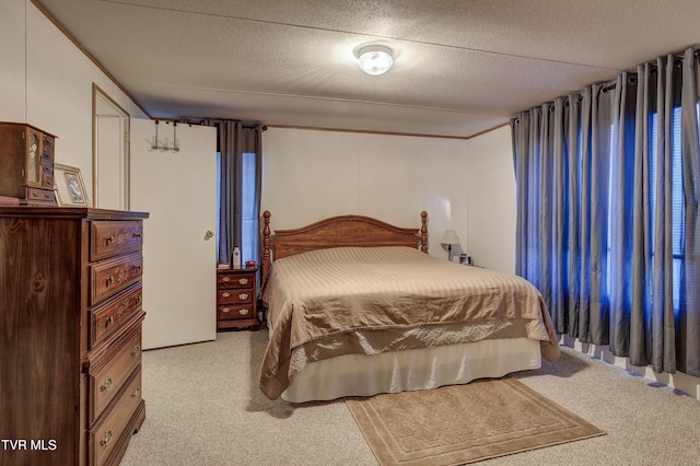 bedroom with a textured ceiling and light colored carpet