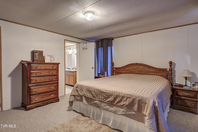 carpeted bedroom featuring a textured ceiling and ensuite bathroom