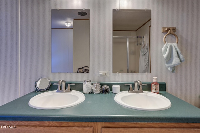 bathroom featuring a shower with door and vanity