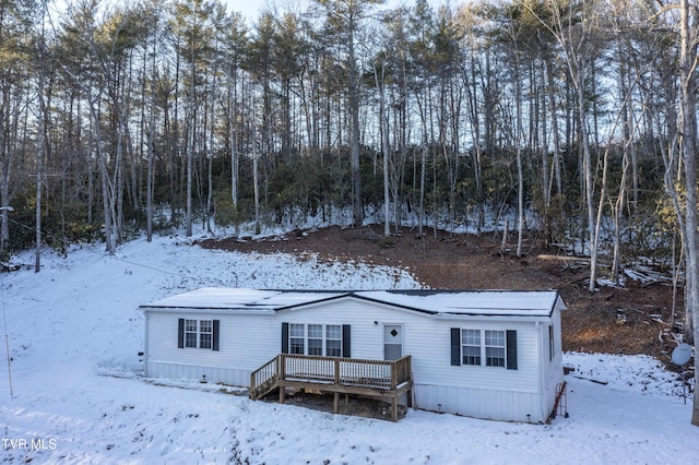 snow covered house featuring a wooden deck