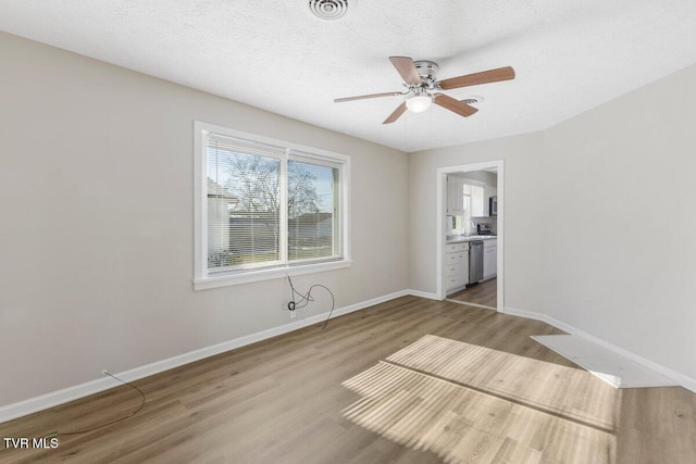 spare room featuring ceiling fan, sink, a textured ceiling, and hardwood / wood-style flooring