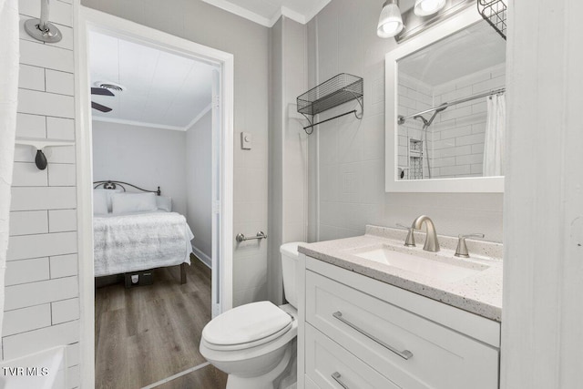 bathroom featuring toilet, hardwood / wood-style flooring, walk in shower, crown molding, and vanity