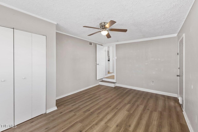 unfurnished bedroom featuring ceiling fan, dark wood-type flooring, a textured ceiling, and a closet