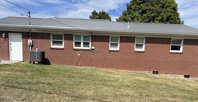 view of side of property featuring a lawn and central air condition unit