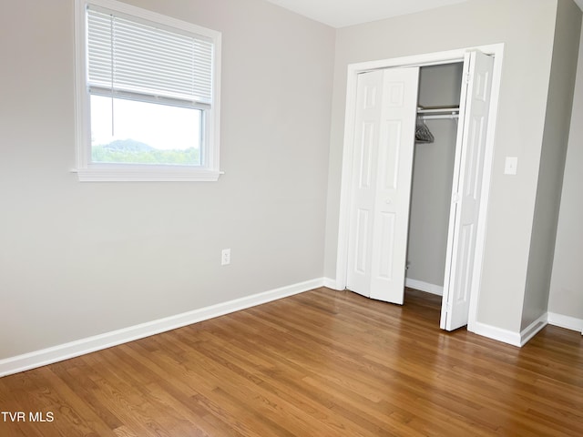 unfurnished bedroom with hardwood / wood-style flooring and a closet