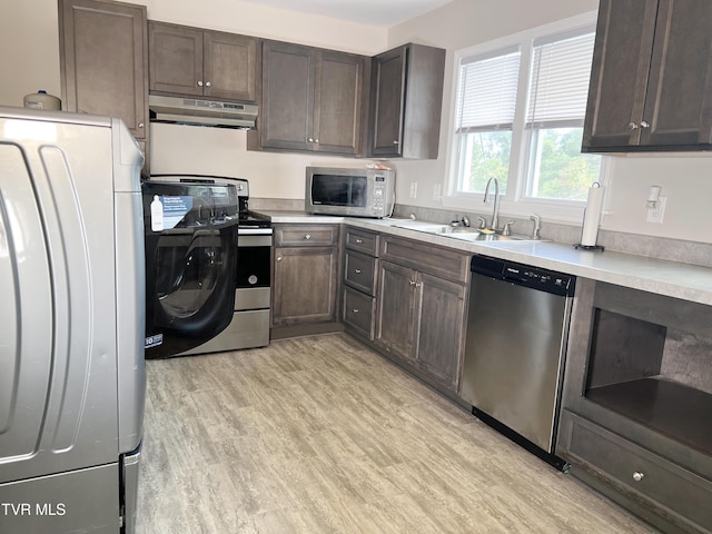 kitchen featuring dark brown cabinetry, washer / clothes dryer, stainless steel appliances, sink, and light hardwood / wood-style flooring