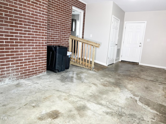 unfurnished living room with brick wall and concrete flooring