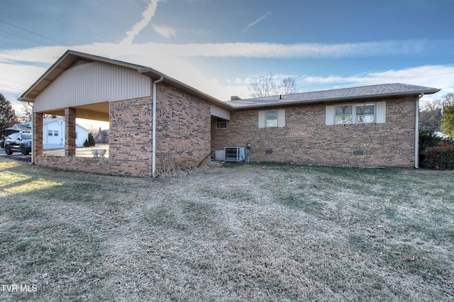 view of side of property featuring cooling unit and a yard