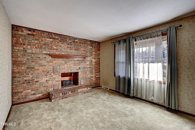 unfurnished living room with carpet floors, a fireplace, and a textured ceiling