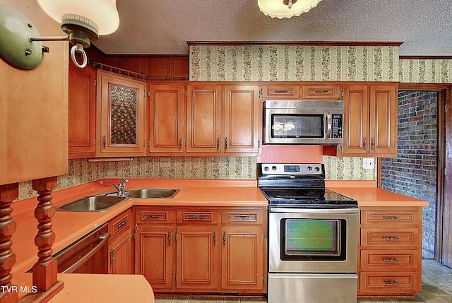 kitchen with sink, a textured ceiling, and appliances with stainless steel finishes