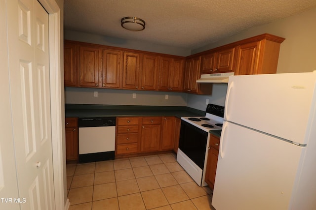 kitchen with white appliances, a textured ceiling, and light tile patterned flooring