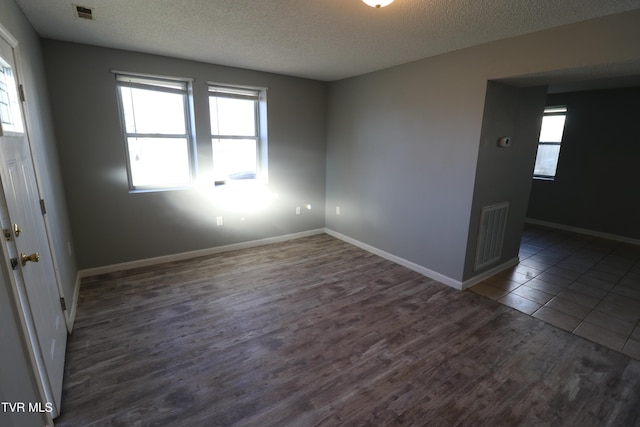 tiled spare room with a textured ceiling