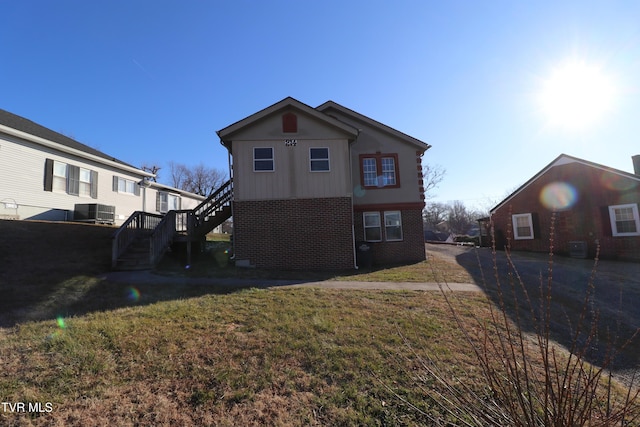 back of property with a lawn and central air condition unit