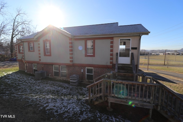 rear view of house featuring central AC unit