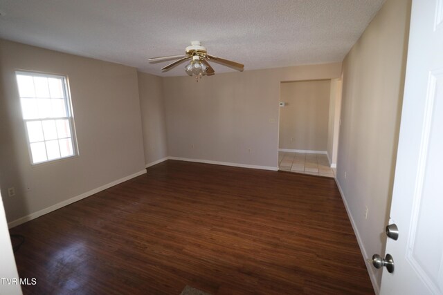 spare room featuring ceiling fan, a textured ceiling, and dark hardwood / wood-style floors