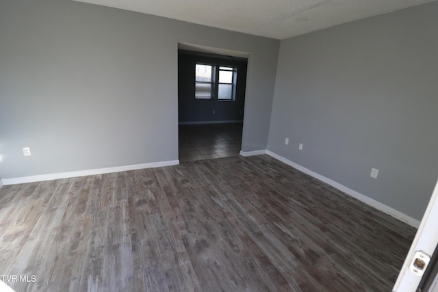 unfurnished room featuring a textured ceiling and dark hardwood / wood-style floors