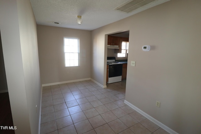 tiled spare room with a textured ceiling