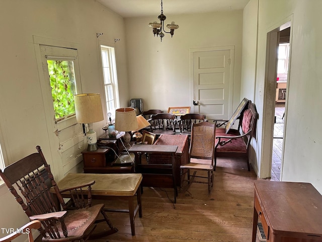 dining area with dark wood-type flooring and a chandelier