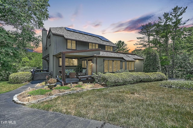 back house at dusk featuring a yard