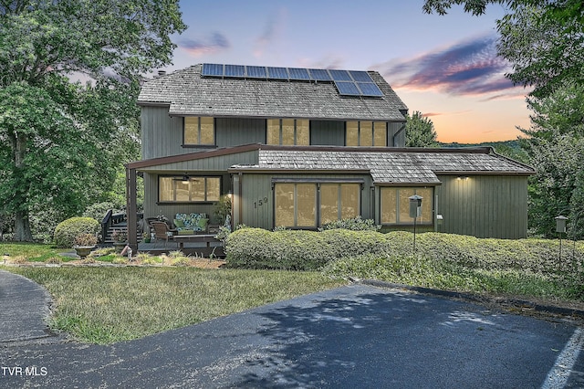 exterior space with an outdoor hangout area, solar panels, and a yard