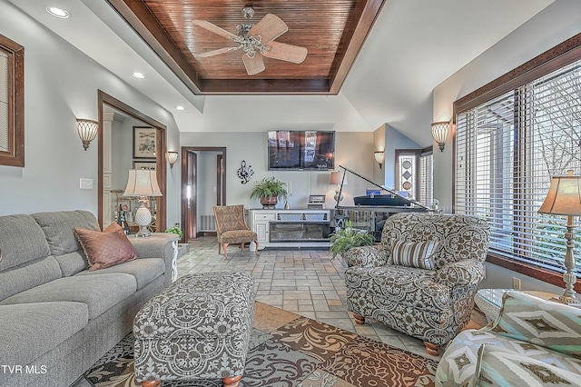 living room featuring ceiling fan, a tray ceiling, and wooden ceiling