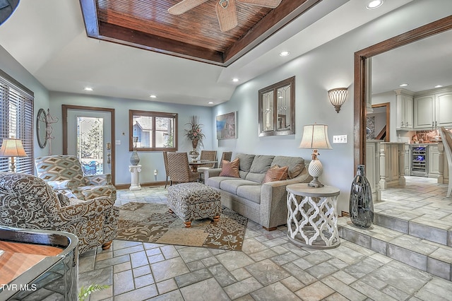 living room featuring ceiling fan, wooden ceiling, beverage cooler, and a tray ceiling