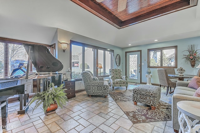 living room with ceiling fan, a wealth of natural light, and wooden ceiling