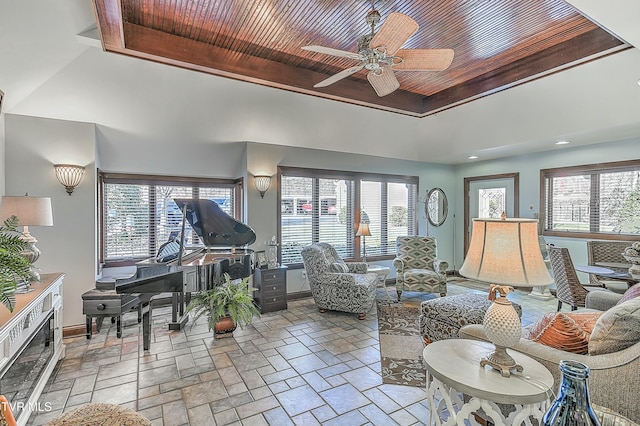 living room featuring wooden ceiling, a towering ceiling, a raised ceiling, and ceiling fan