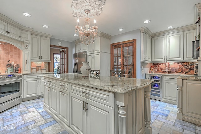 kitchen featuring appliances with stainless steel finishes, a center island, decorative light fixtures, wine cooler, and decorative backsplash