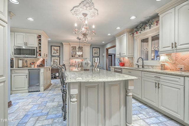 kitchen featuring a breakfast bar area, backsplash, a center island, hanging light fixtures, and sink