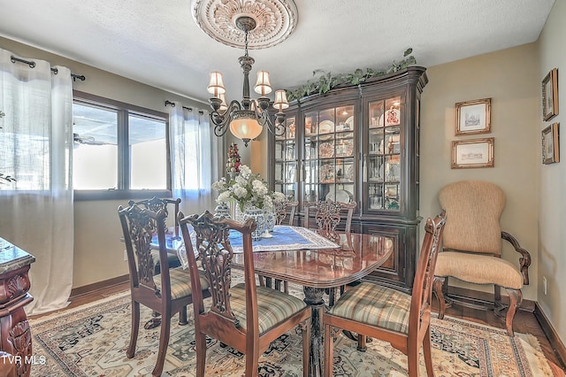 dining space featuring hardwood / wood-style floors, a chandelier, and a textured ceiling