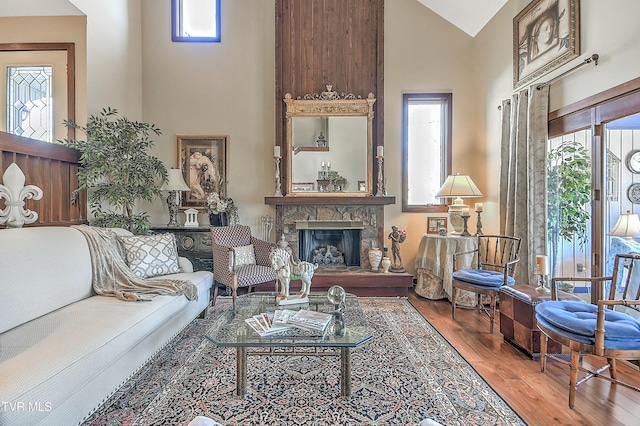 living room featuring a fireplace, hardwood / wood-style floors, and high vaulted ceiling